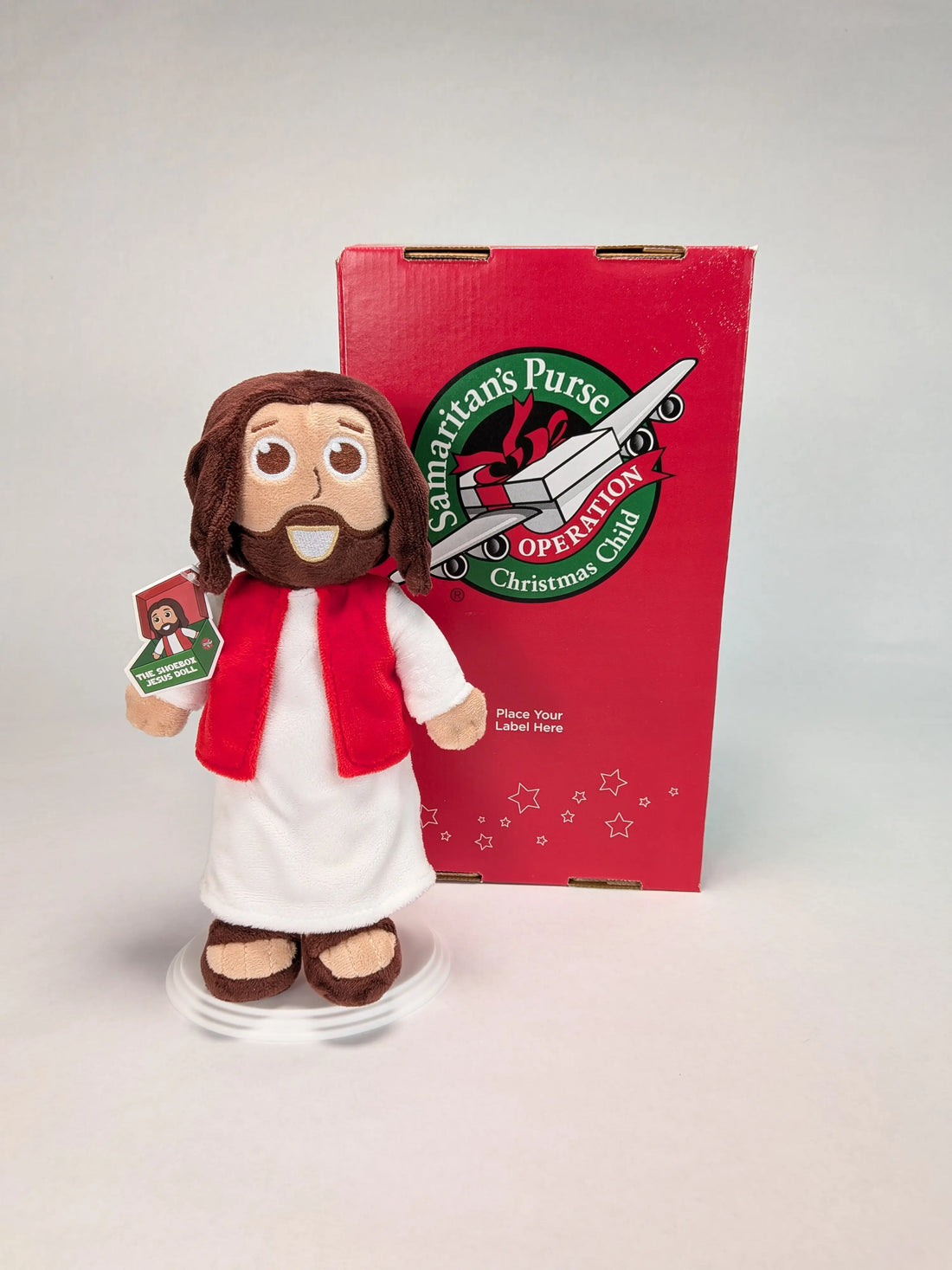 The Shoebox Jesus Doll, a plush Jesus toy from Jesusdoll.com, standing next to a Samaritan&
