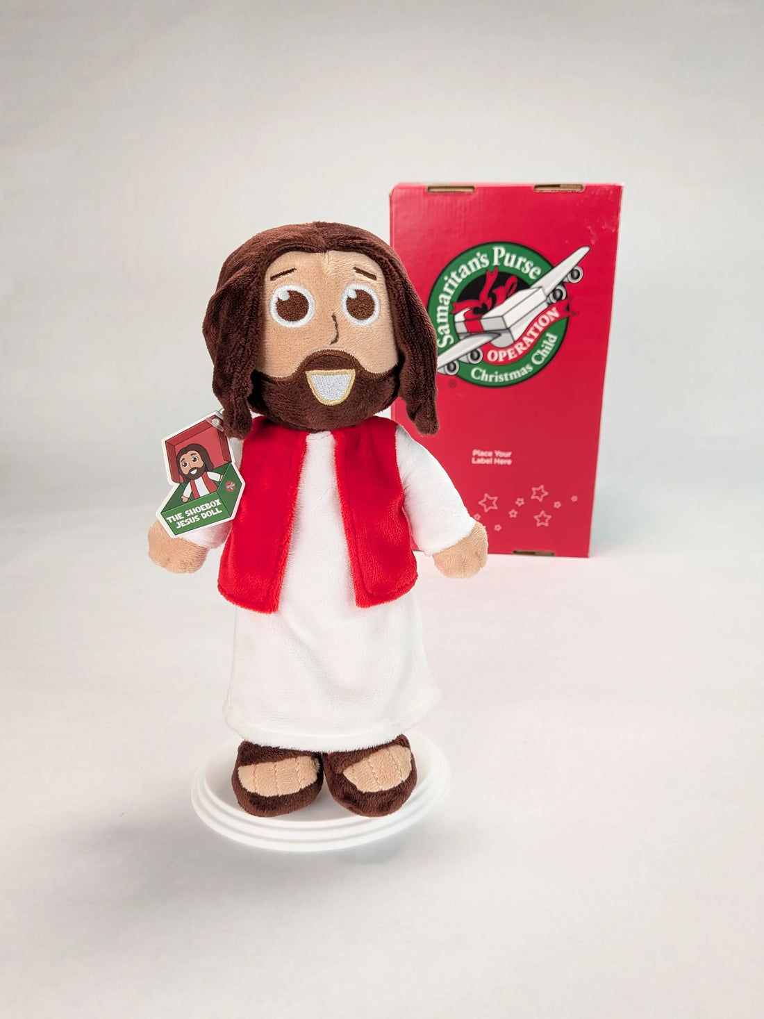 The Shoebox Jesus Doll from Jesusdoll.com with an Operation Christmas Child shoebox in the background.